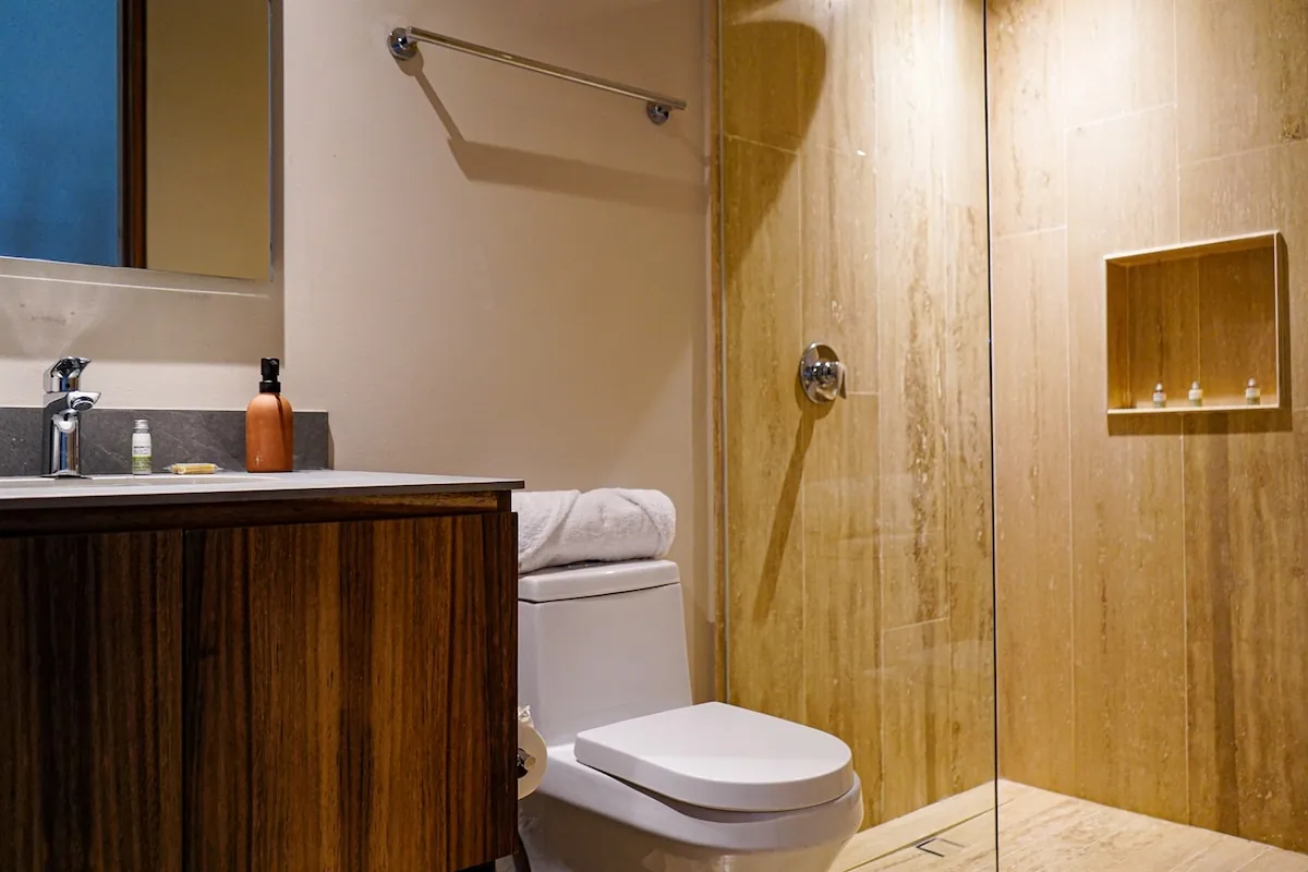 Segundo baño con regadera de mármol travertino y mueble de madera maciza