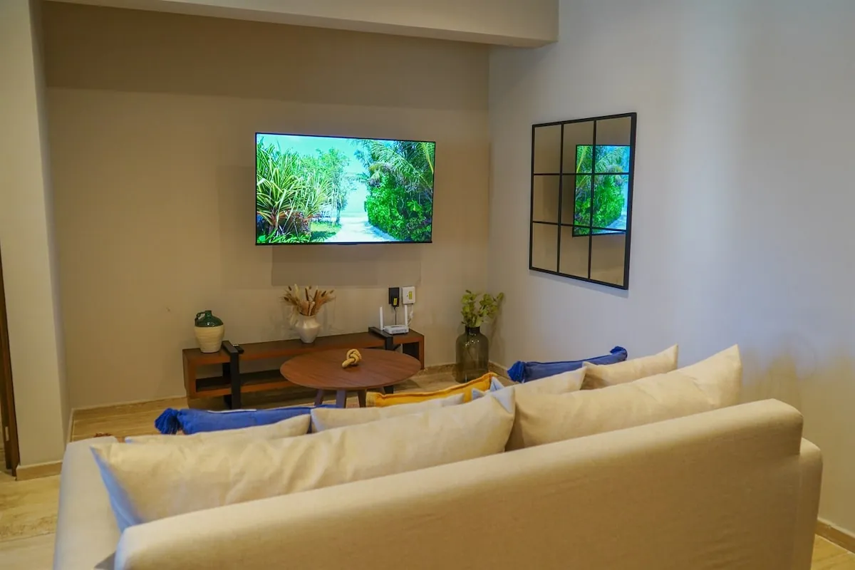Sala con sofá beige, televisión y mesa de centro baja